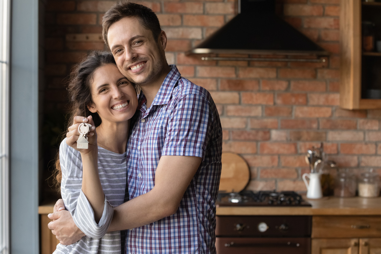 Portrait of happy couple renters show house keys